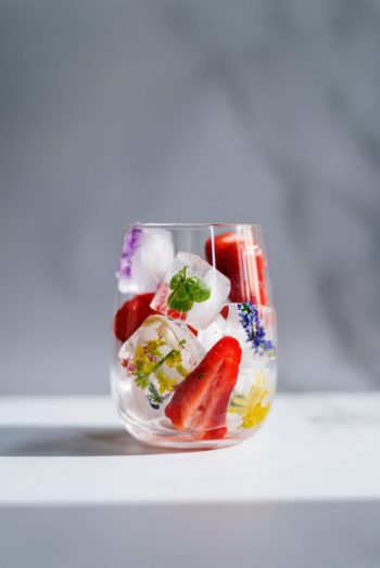 Edible Flowers in Ice Cubes in Glass with Fruit